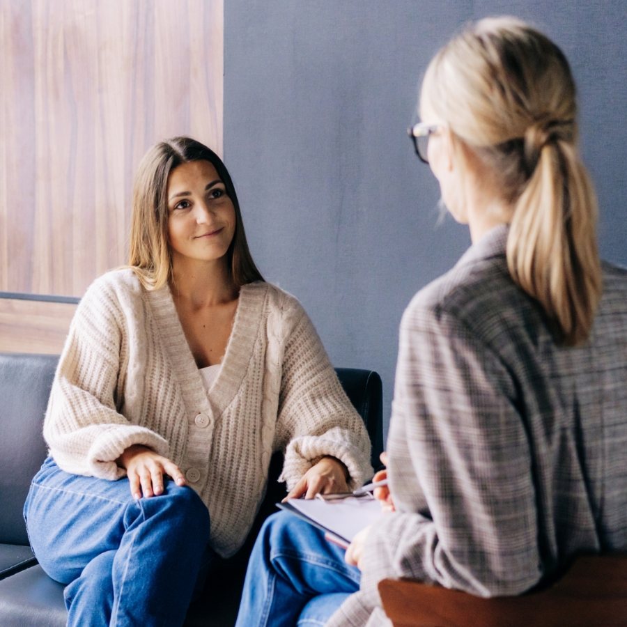 Duas mulheres sentadas frente a frente em uma sessão de escuta